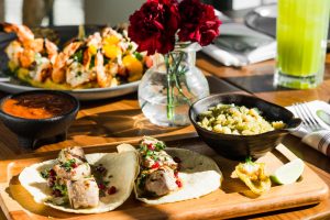 Mexican food with red floors on table and green drink.