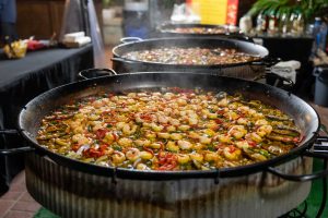 Large iron pan with steaming shrimp and chopped red peppers